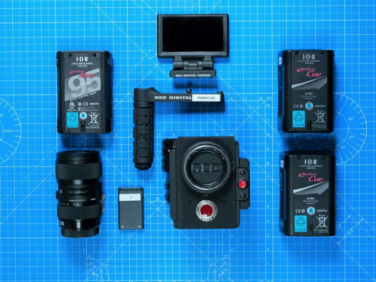 Top view of professional camera equipment arranged on a blueprint surface. High-tech gear for film production.